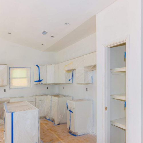 Finishing works in spray painting wall of a new kitchen
