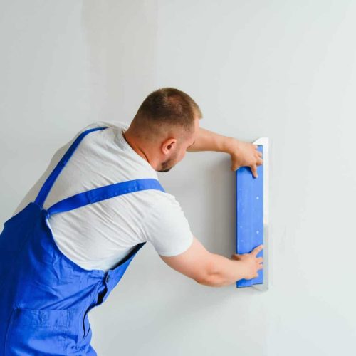 Plasterer smoothes the wall surface with a wall grinder.